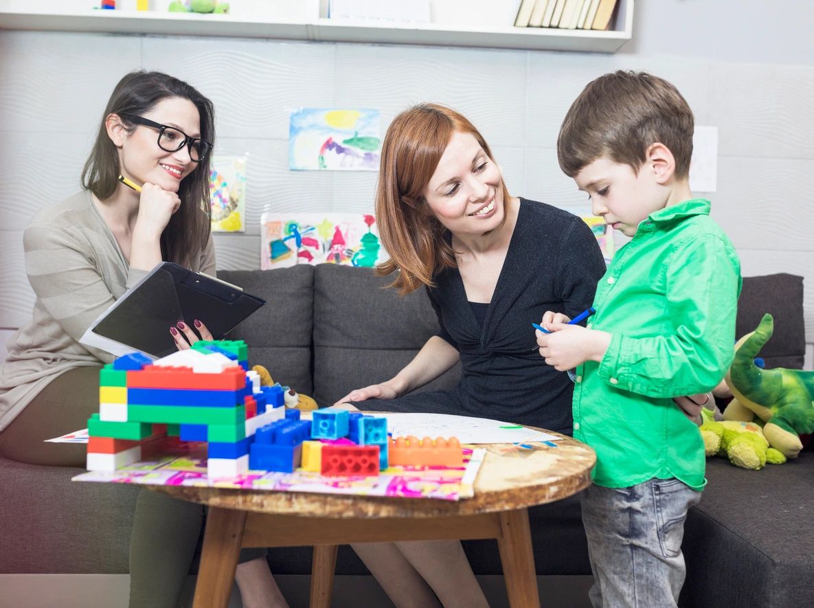 Educators and caregivers with children at a table with building blocks